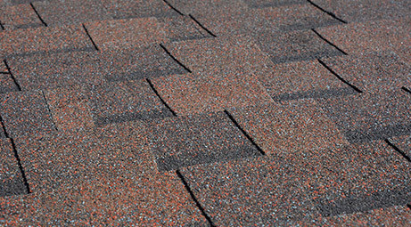 Roof with brown asphalt shingles. Patterned shingles.