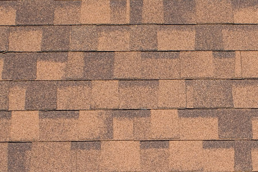 Brown roof shingles with a unique pattern. Roofing material texture