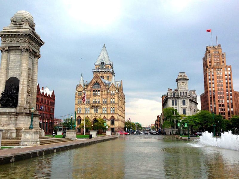 a large building with a white spire and a fountain in the foreground