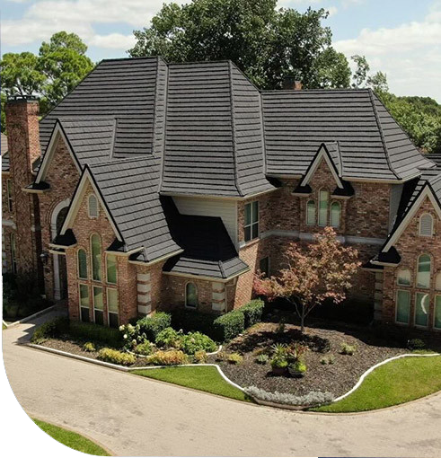 A house with a porch and garden. The house is old and has a tiled roof.
