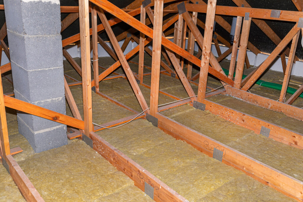 Attic insulation and wooden roof trusses. A well insulated attic space.