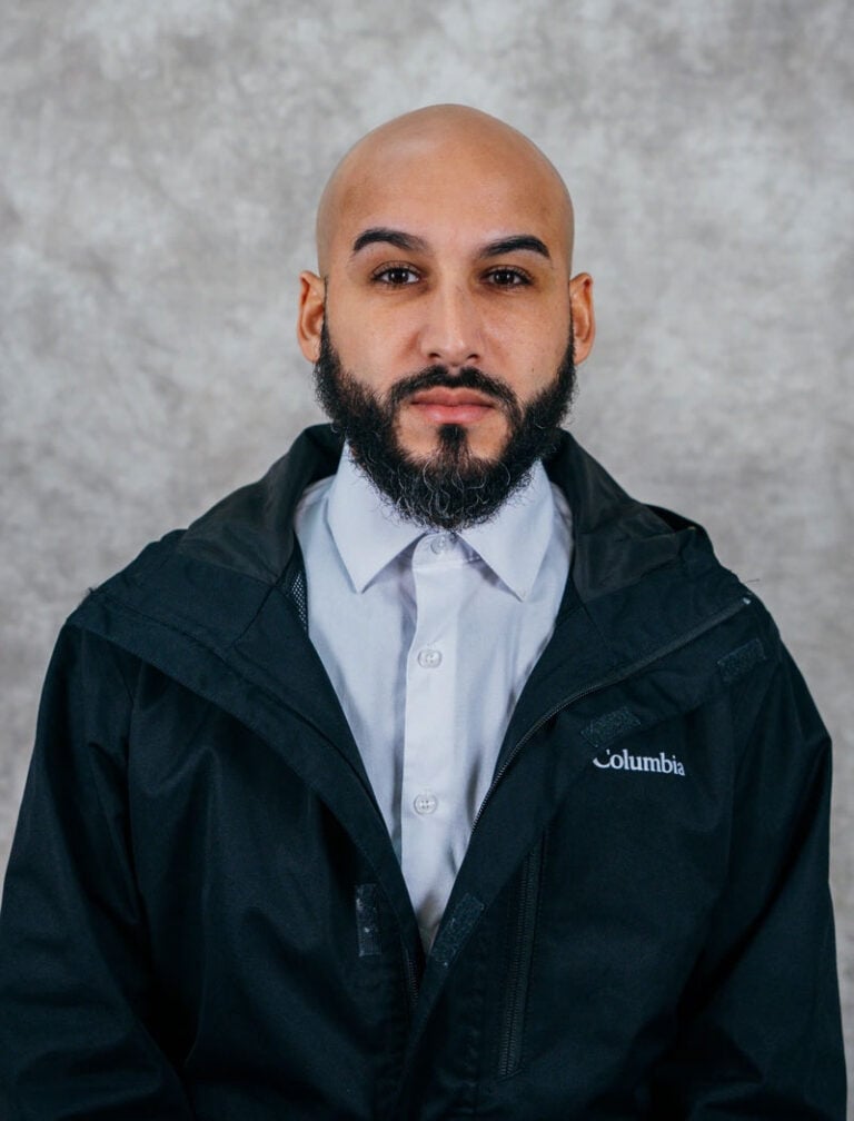 A man with a beard and mustache wearing a Columbia jacket.