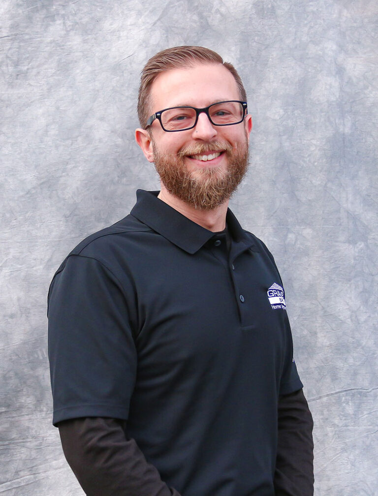 Man wearing black glasses and a black polo shirt. He appears to be a professional.