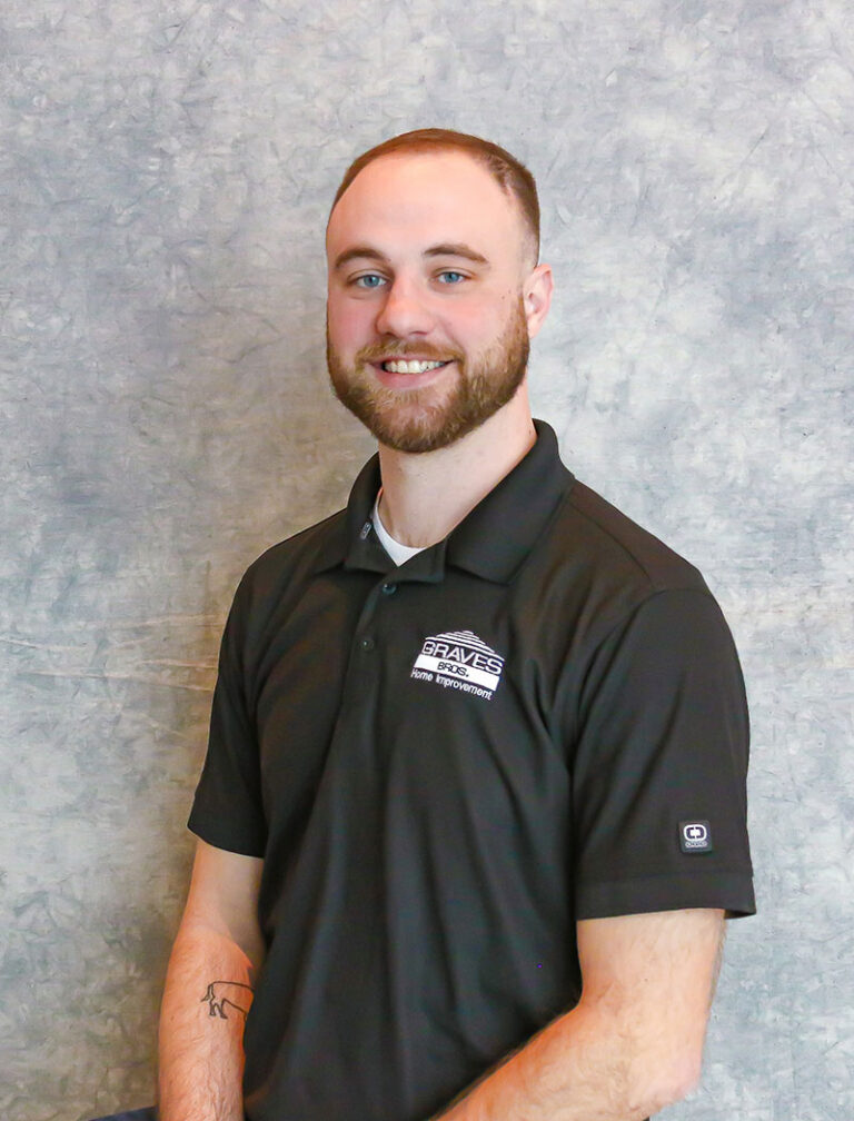 A man with a beard and short hair wearing a black polo shirt