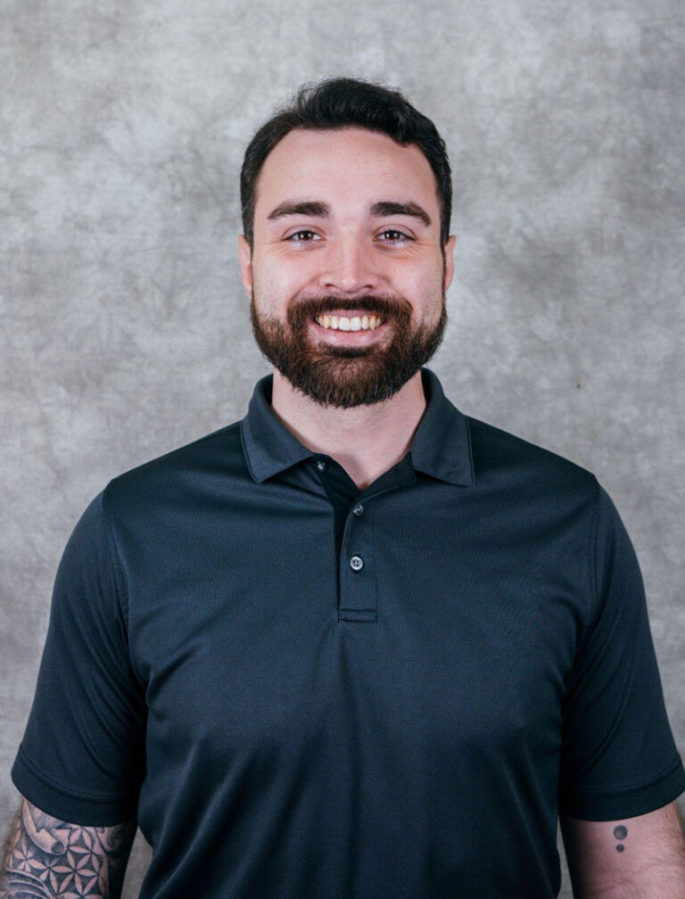 A man with a beard and tattoos on his arms