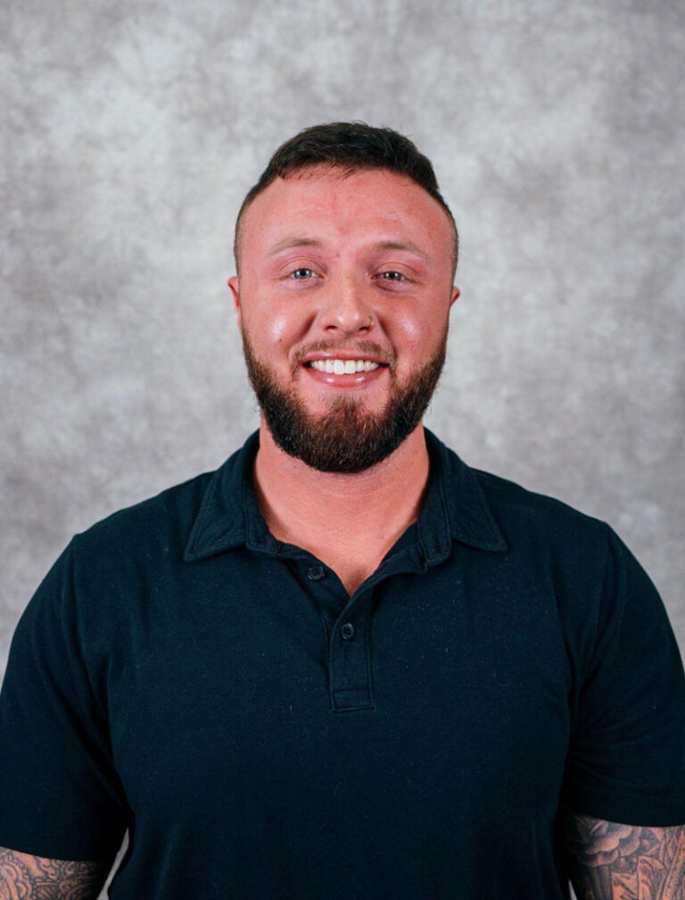A man with short hair and a beard smiling