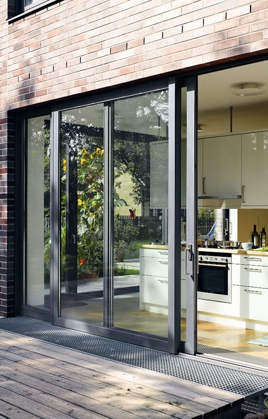 Modern kitchen interior with white cabinets and sliding glass doors leading to a patio.