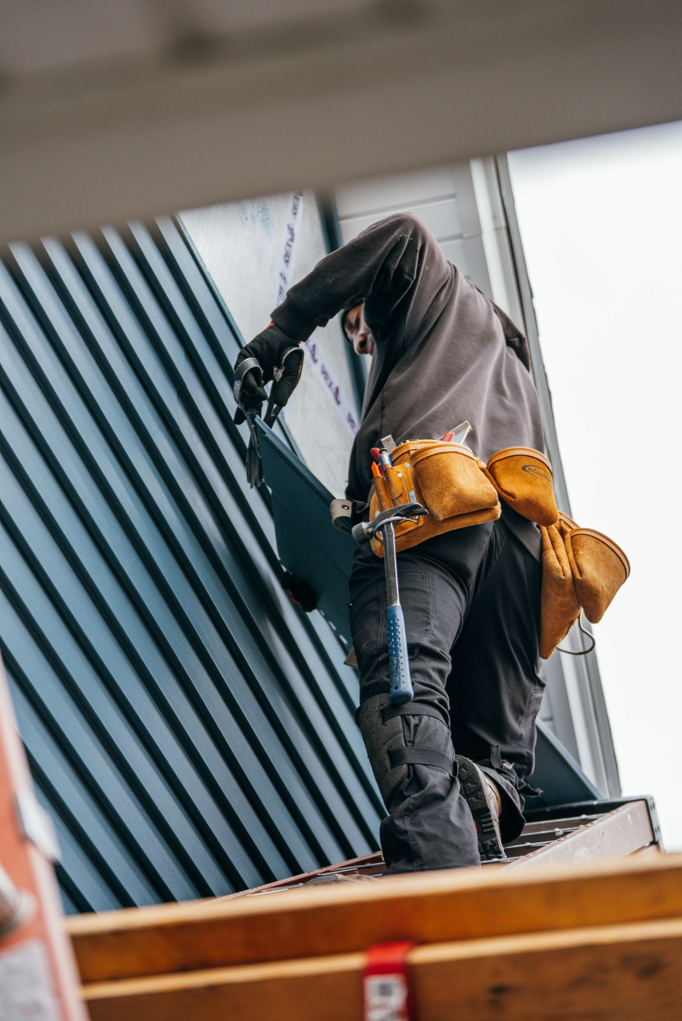 A roofer working on a roof with a tool belt