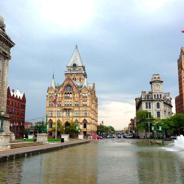 a large building with a white spire and a fountain in the foreground