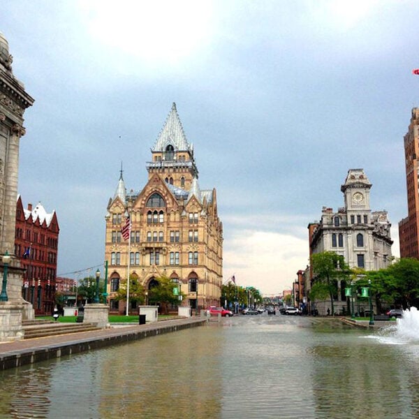 a large building with a white spire and a fountain in the foreground