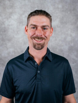 man smiling wearing dark blue polo