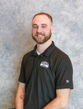 A man with a beard and short hair wearing a black polo shirt