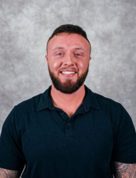 A man with short hair and a beard smiling